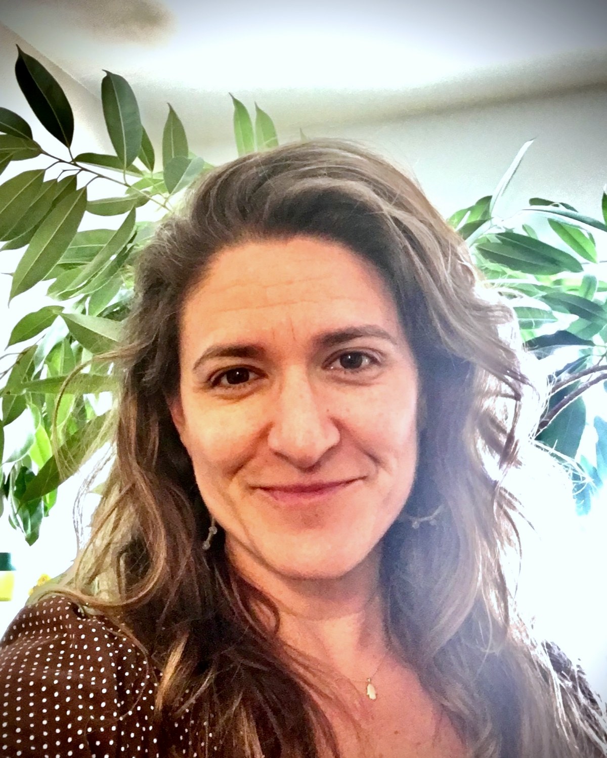 Anna Talamo, LMFT, marriage and family therapist in Albany, California, photographed beside a green plant